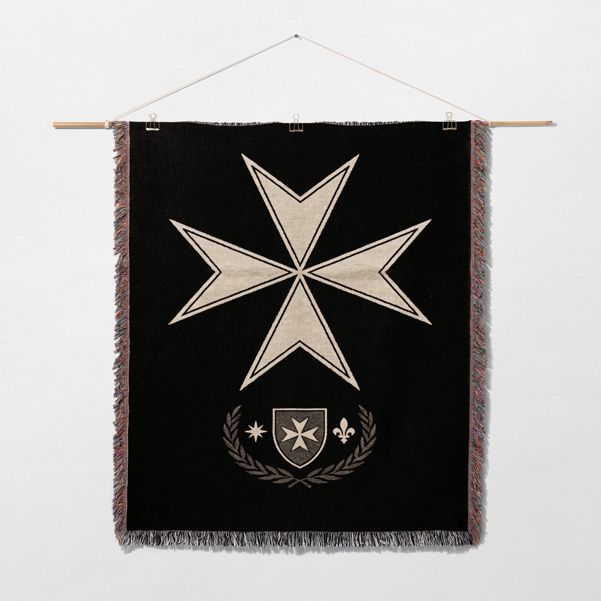 Black tapestry featuring a white Maltese cross over a shield and laurel wreath.