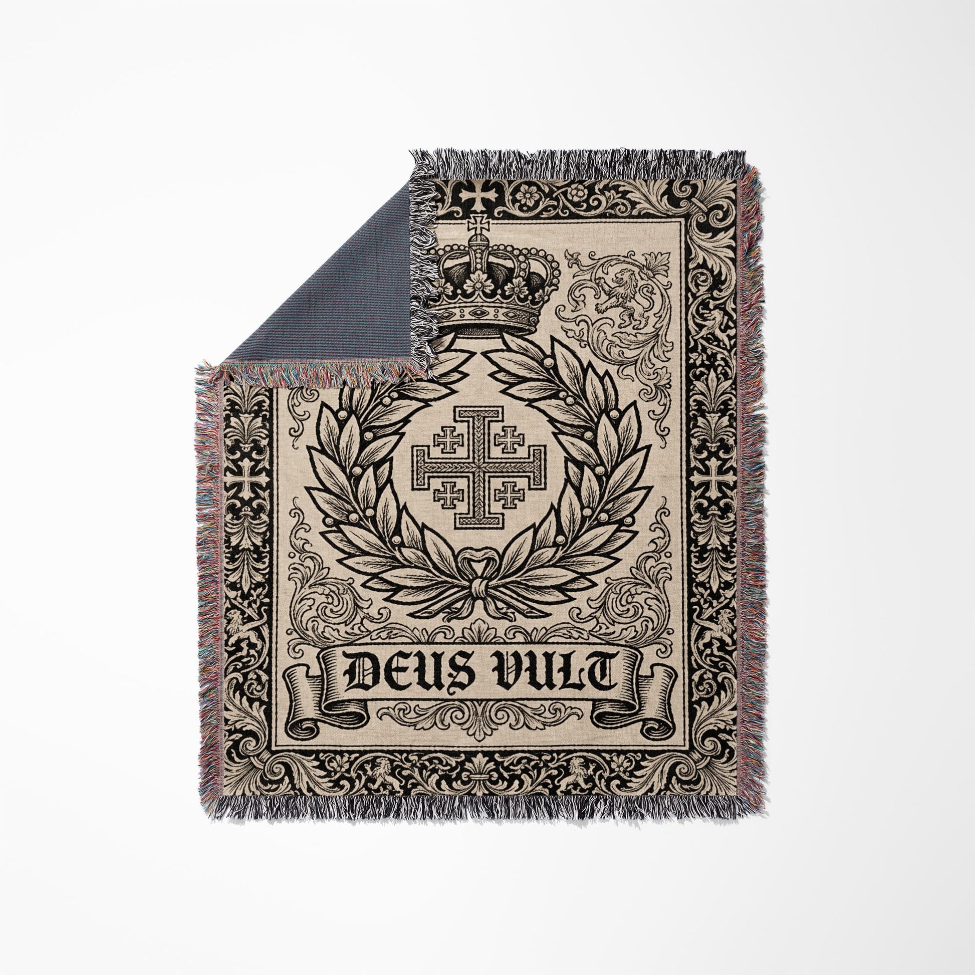 Woven blanket featuring a crown, Jerusalem cross, and "Deus Vult" text on a light background.