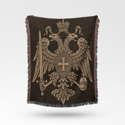 Double-headed eagle coat of arms with sword and orb on a dark patterned throw.