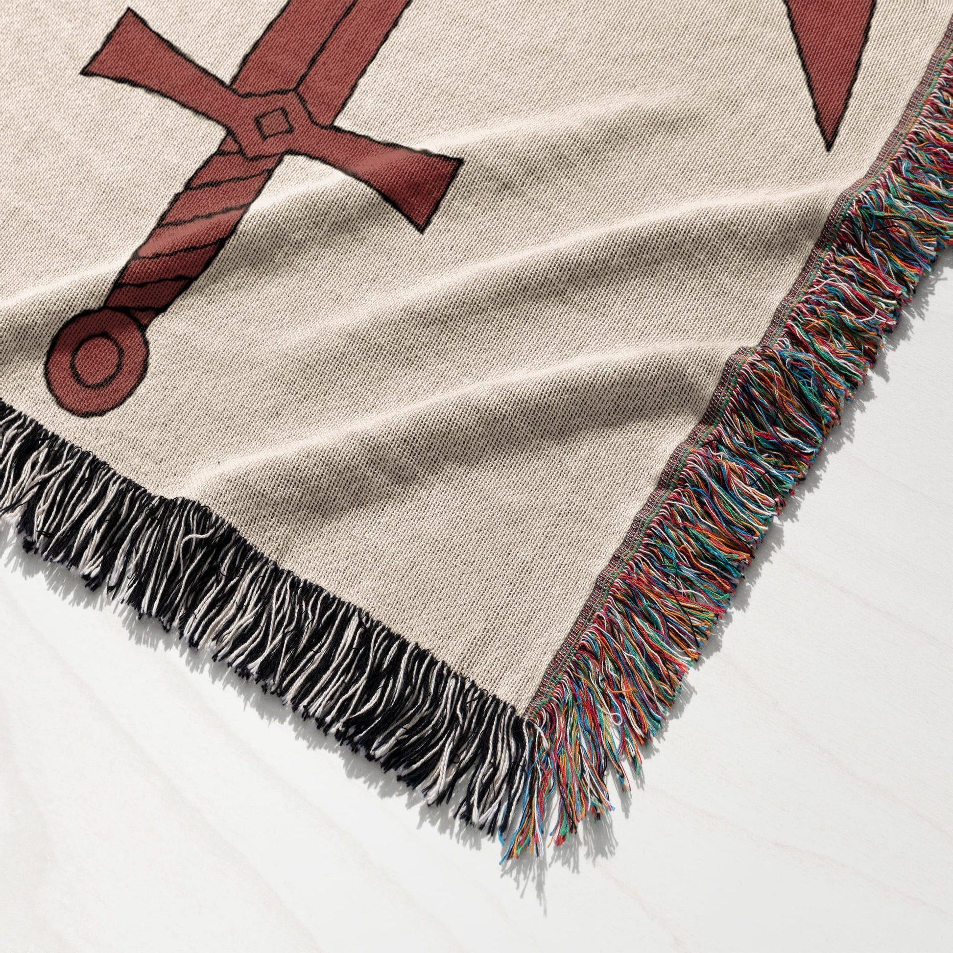 Tapestry blanket with red cross pattern and fringed edge.