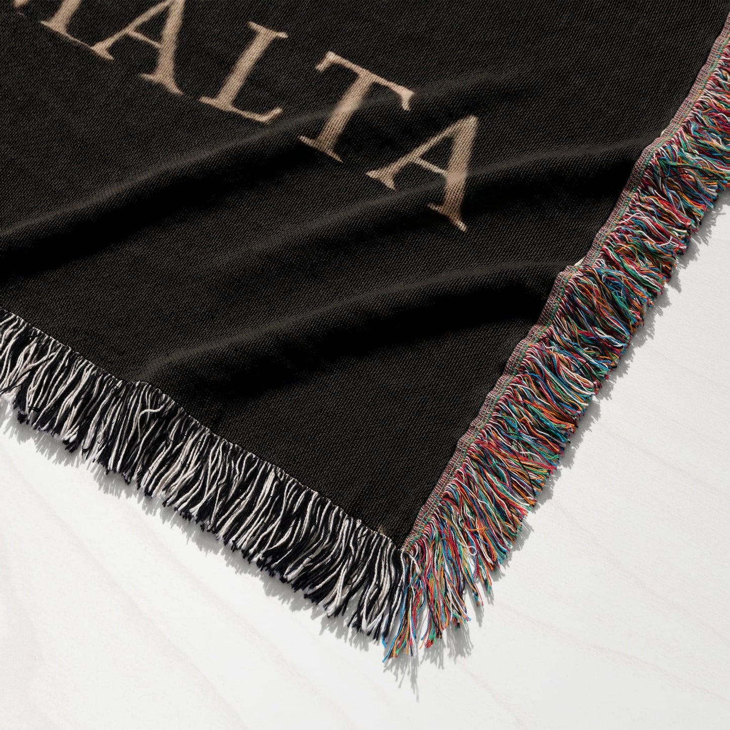 Black woven blanket with fringe and "ALTA" text visible.