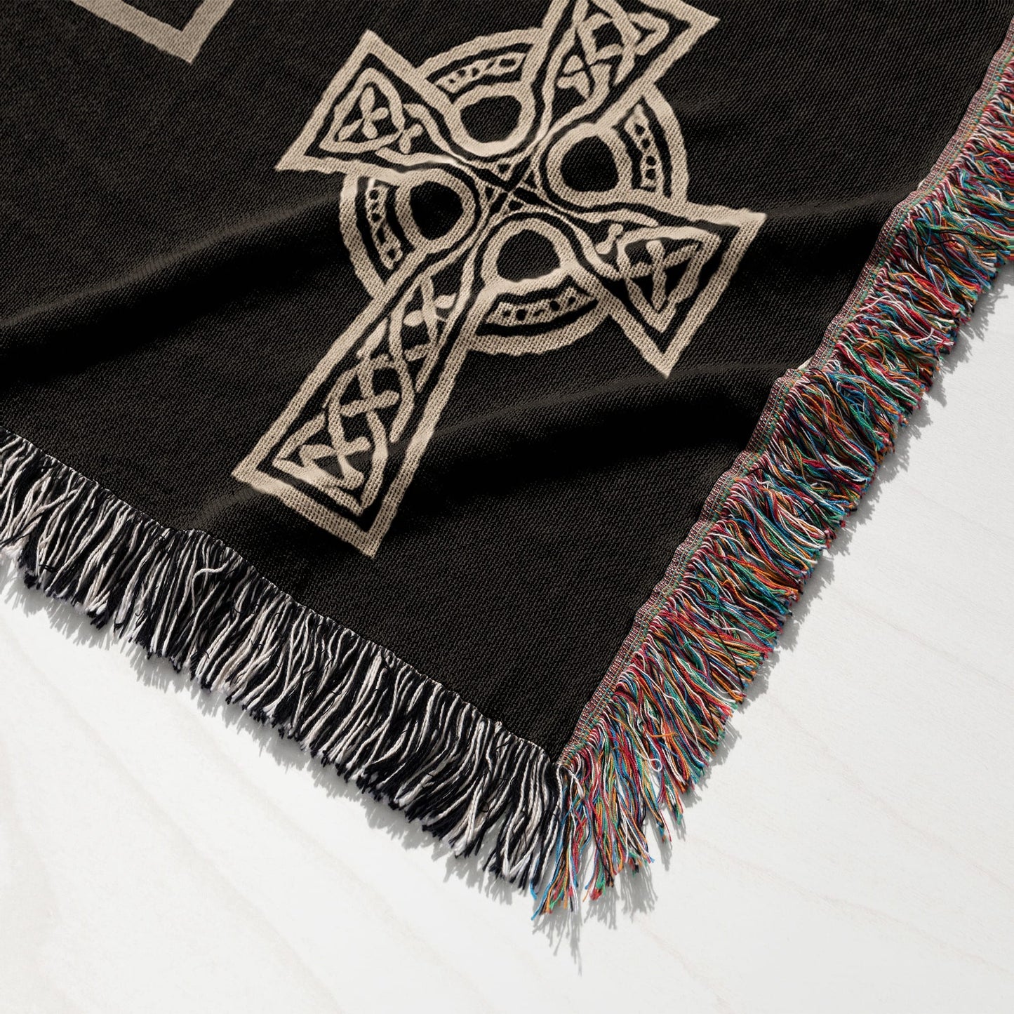 Black throw blanket with Celtic knot cross design and fringed edges.