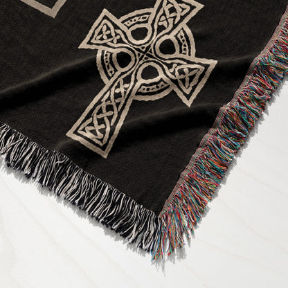 Black throw blanket with Celtic knot cross design and fringed edges.