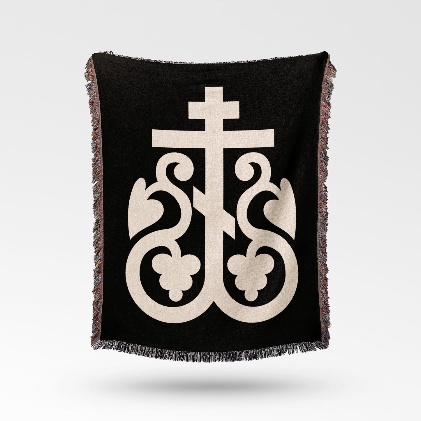 Black throw blanket with a cream Orthodox Christian cross and ornate flourishes.