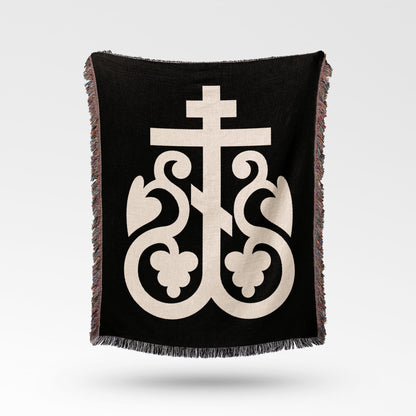 Black throw blanket with a cream Orthodox Christian cross and ornate flourishes.