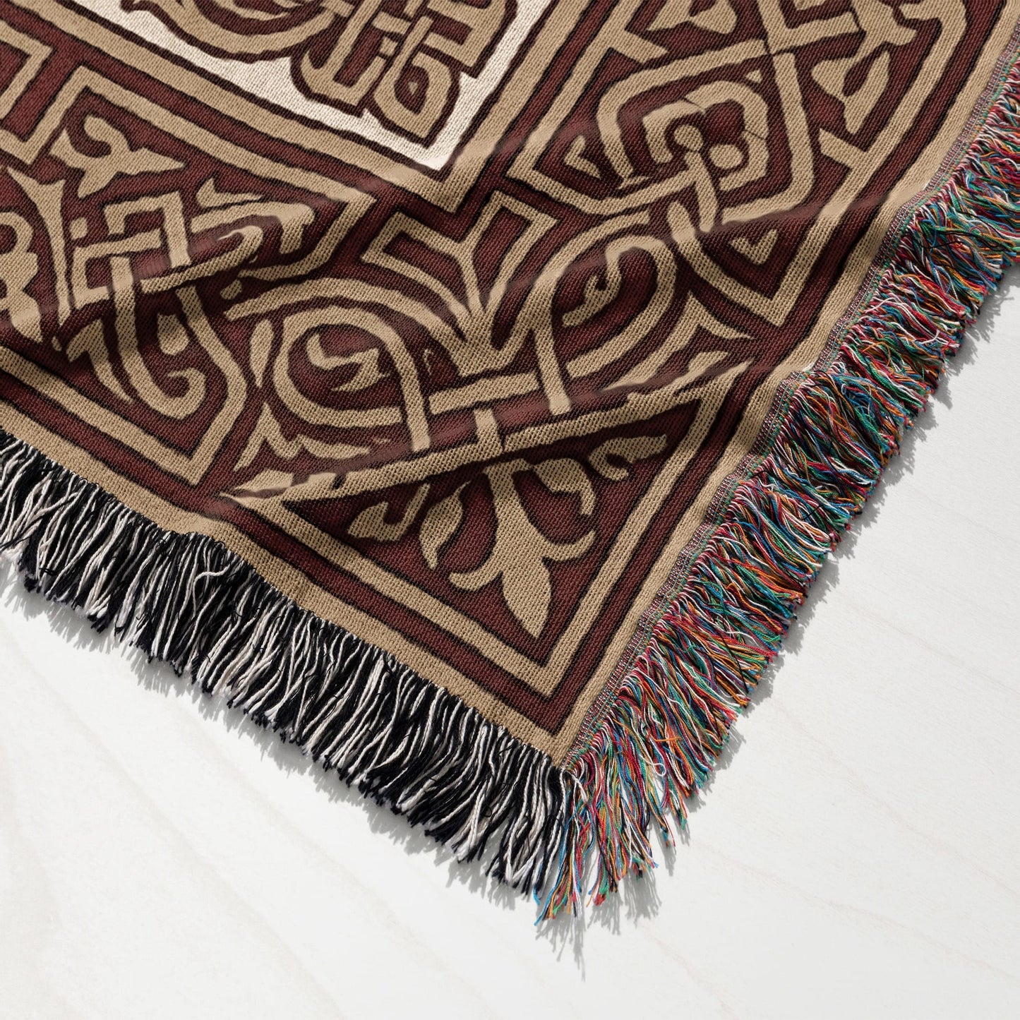Brown and tan woven throw blanket with fringe, detailed geometric pattern.