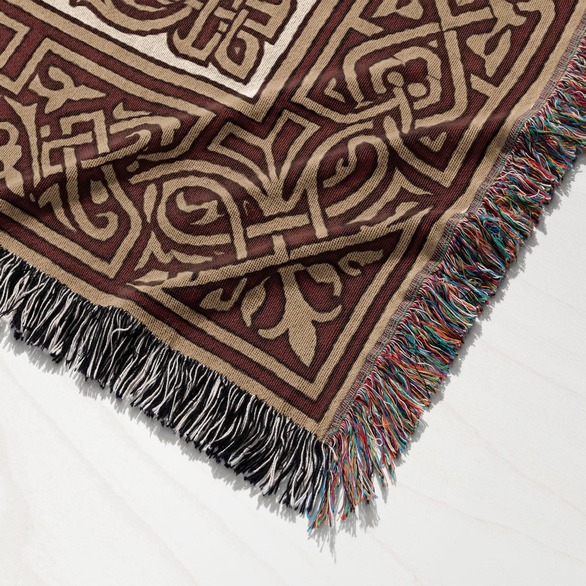 Brown and tan woven throw blanket with fringe, detailed geometric pattern.