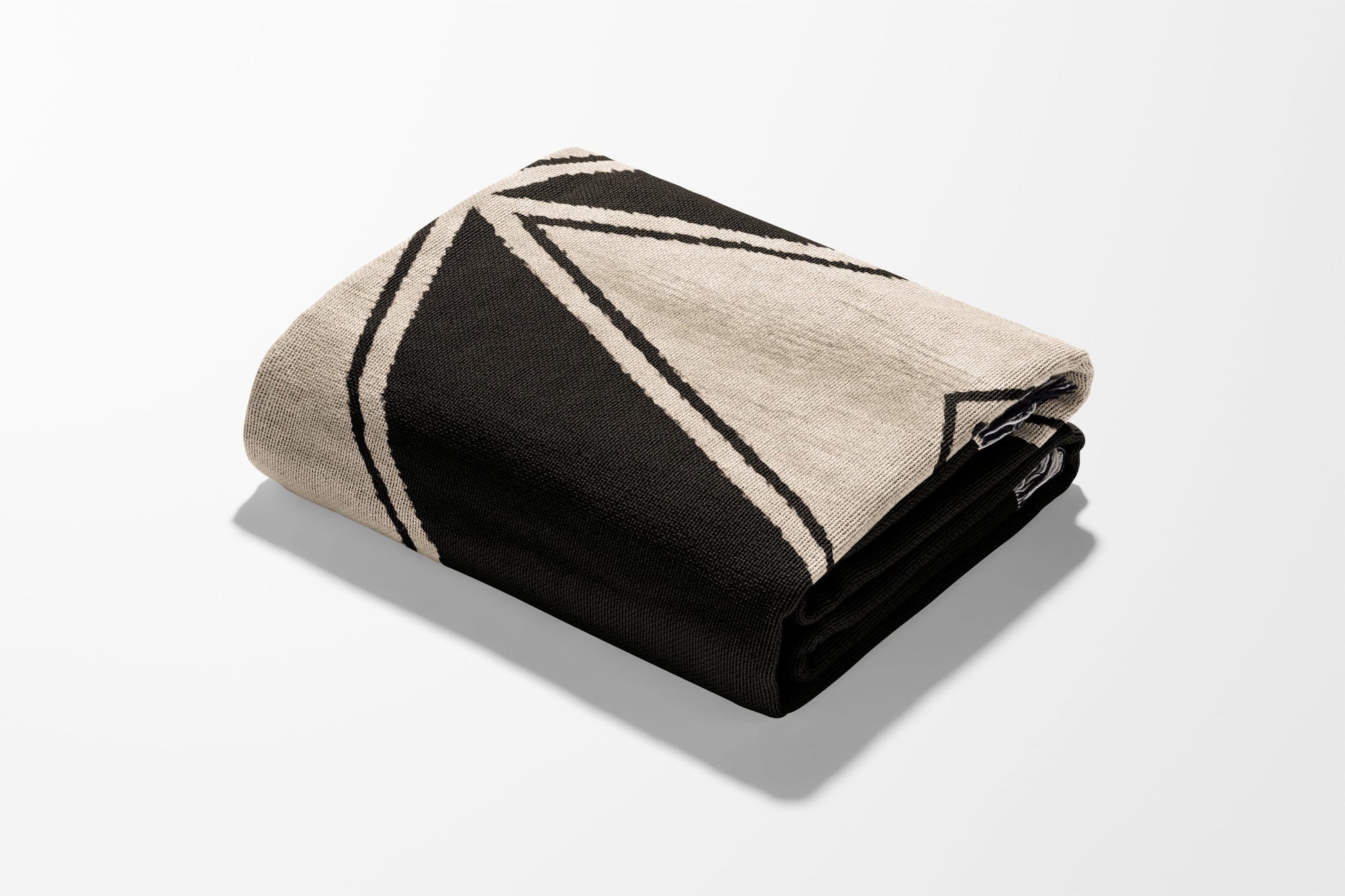 Black and cream geometric pattern folded blanket.