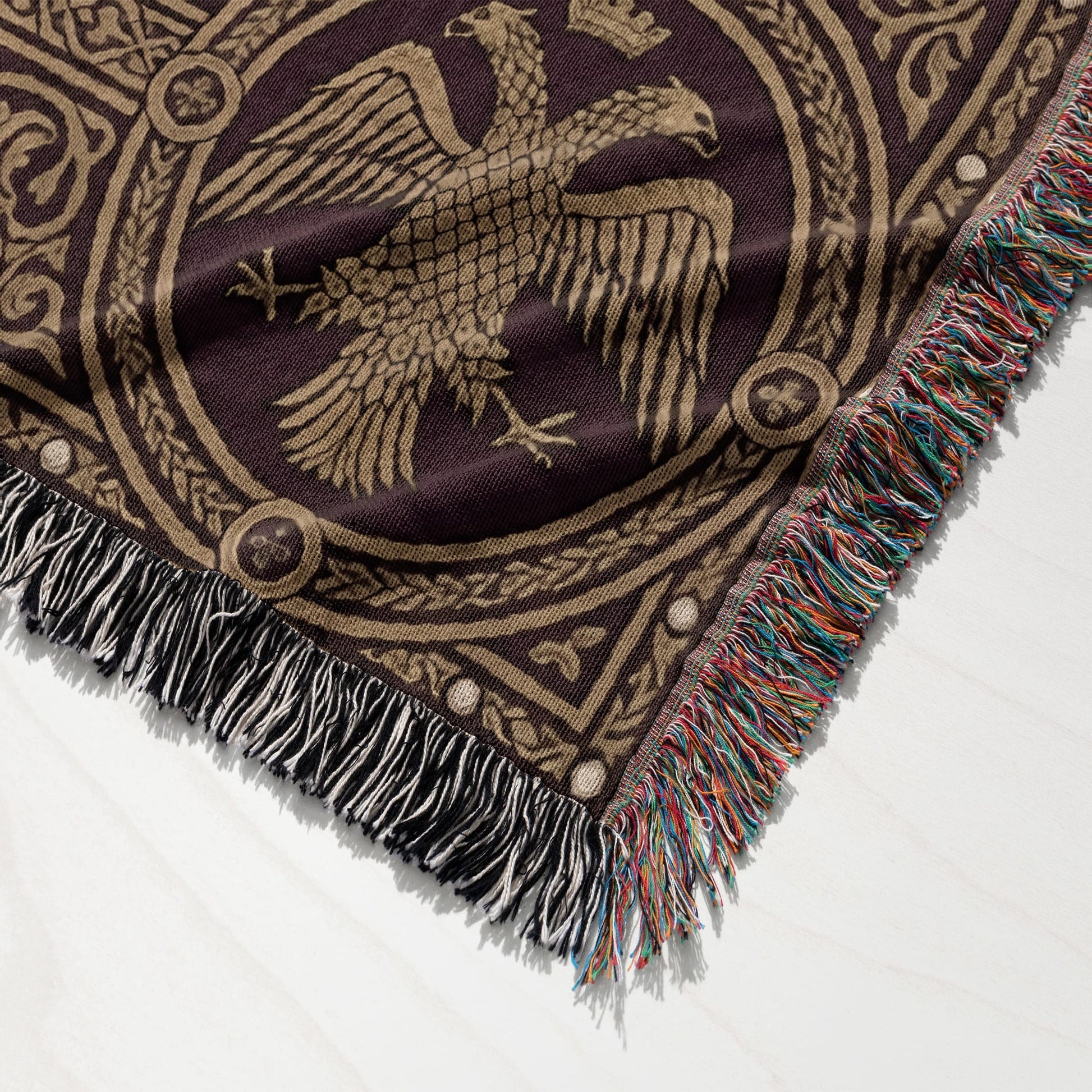 Brown woven blanket with fringed edges and a gold eagle emblem.