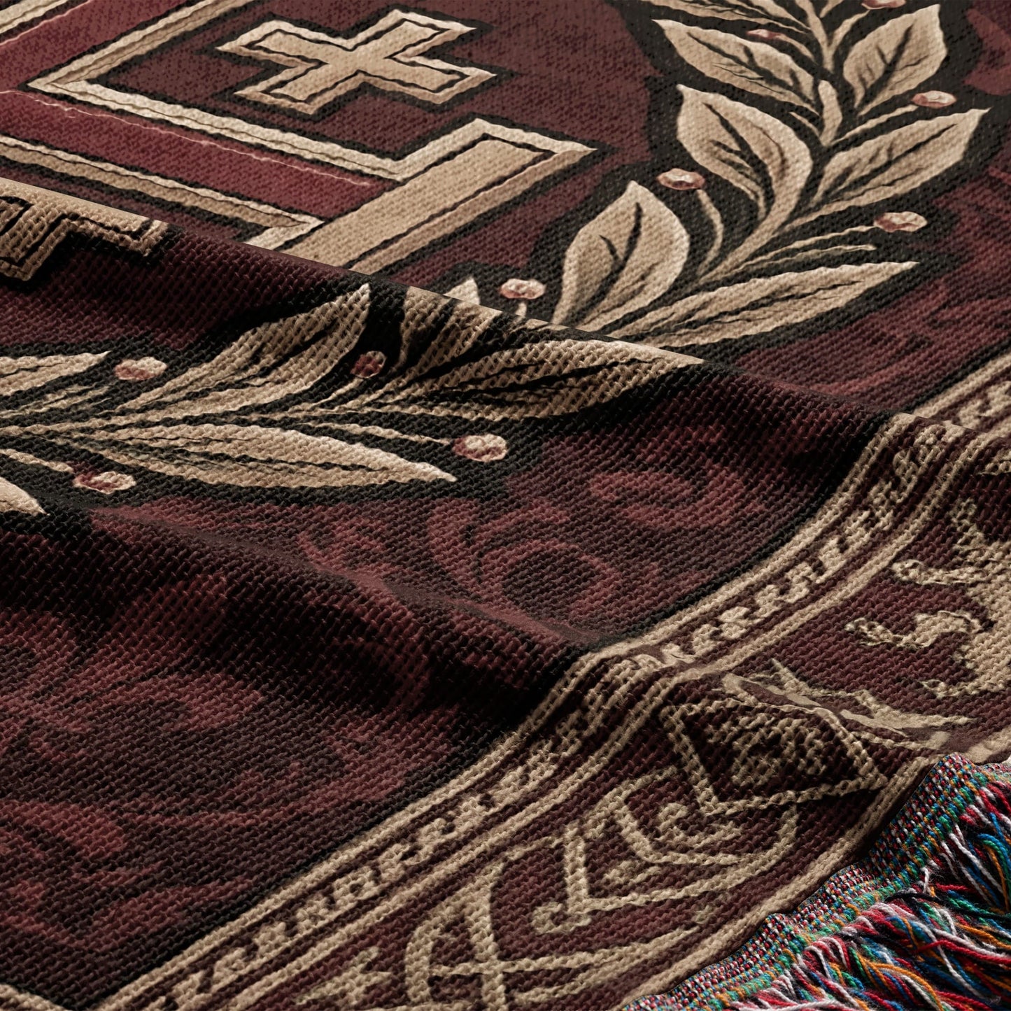 Woven throw with a cross, laurel leaves, and geometric border on dark red.