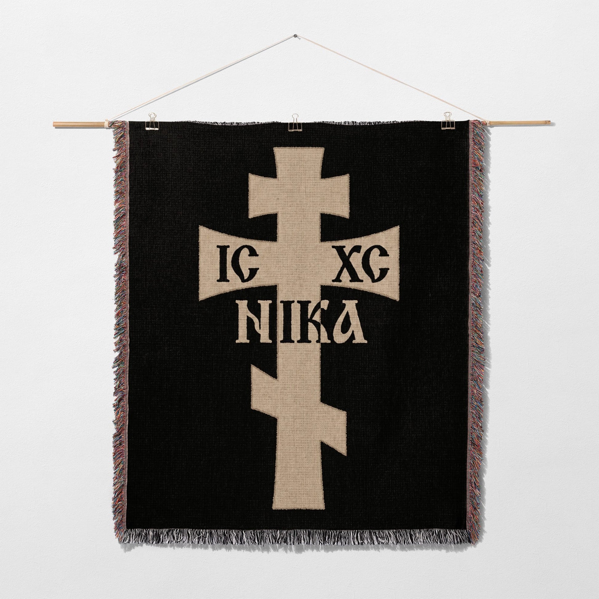 Tan Christian cross with IC XC NIKA text on black woven tapestry.