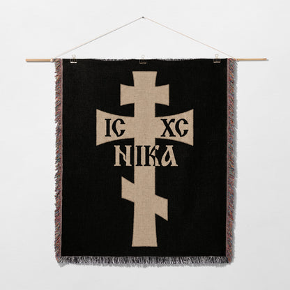 Tan Christian cross with IC XC NIKA text on black woven tapestry.