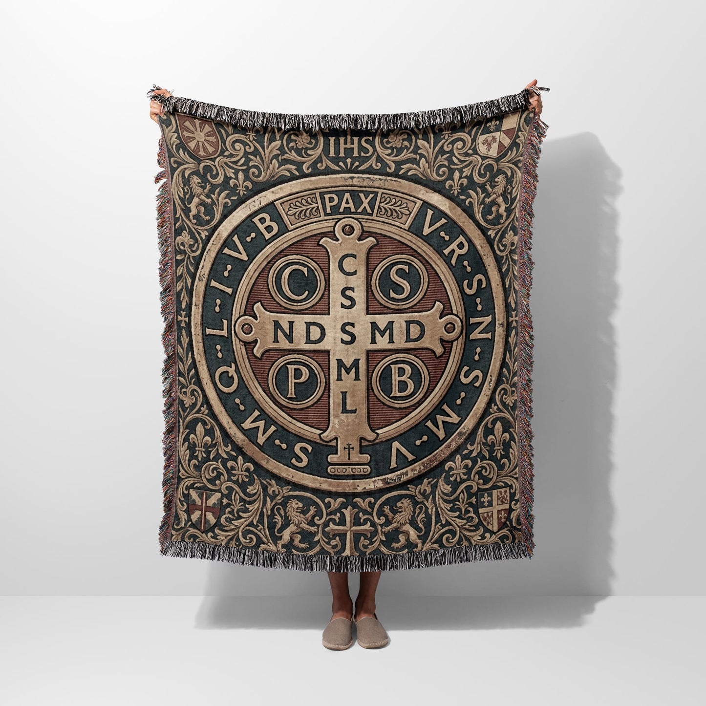 Tapestry throw with St. Benedict medal design, fringe, and lions.