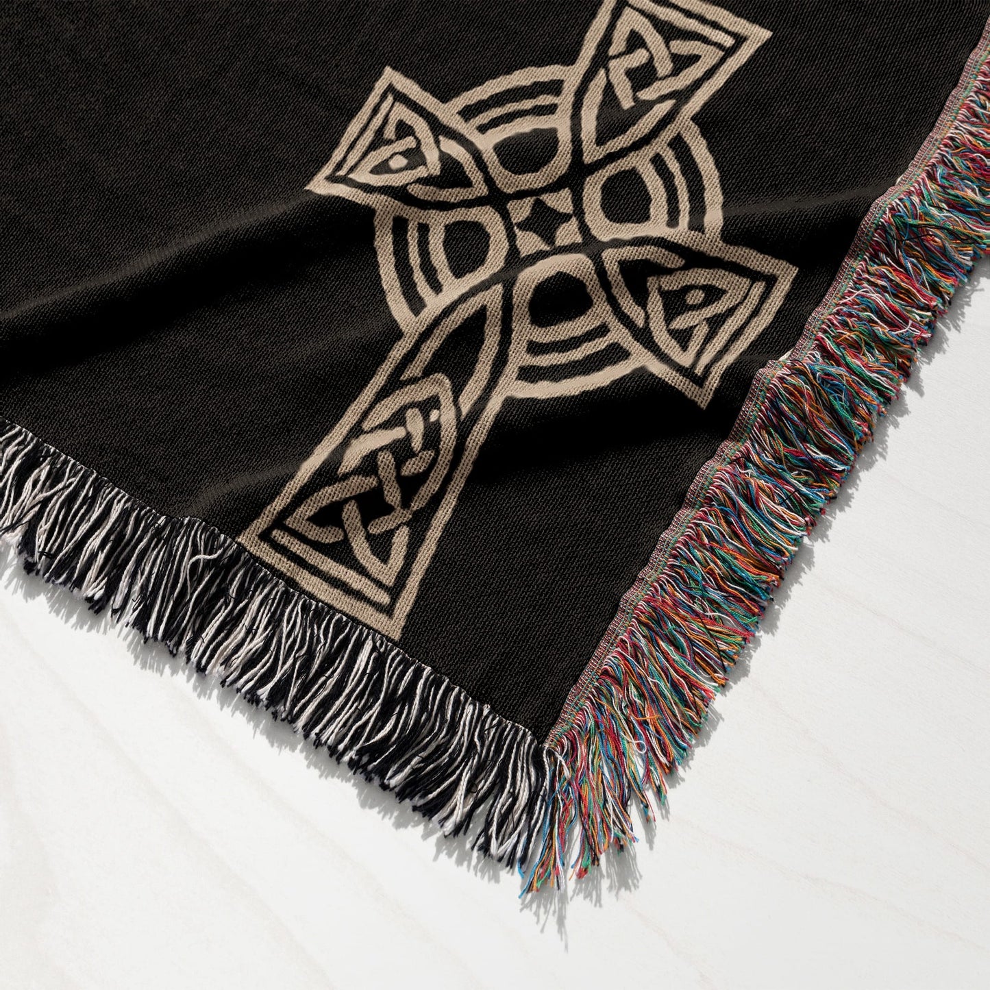 Woven blanket with Celtic knot cross pattern and tasseled edges.
