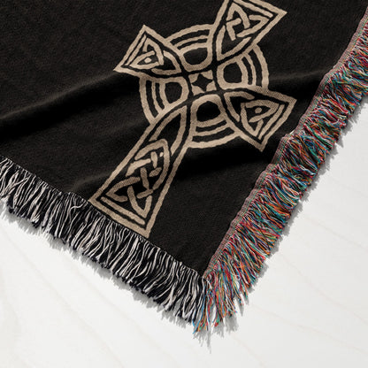 Woven blanket with Celtic knot cross pattern and tasseled edges.