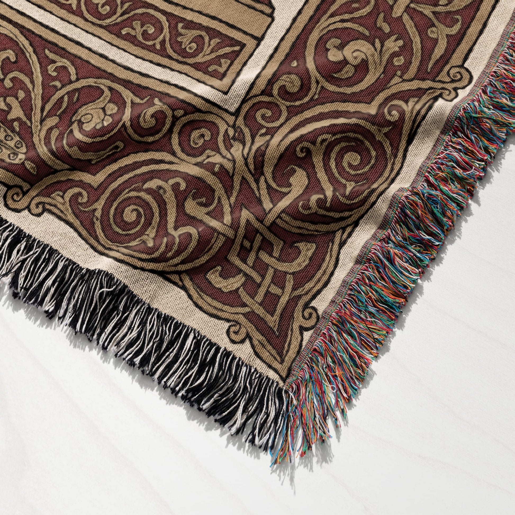 Woven tapestry blanket with intricate Celtic knot pattern and fringed edge.