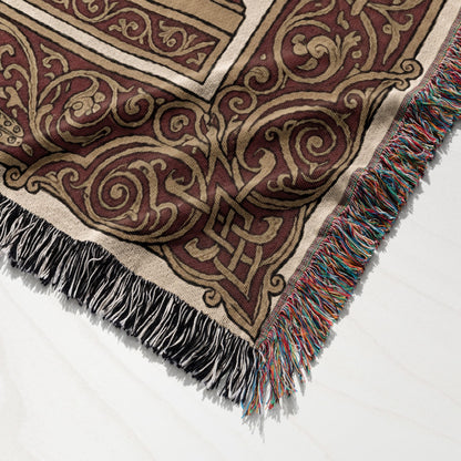 Woven tapestry blanket with intricate Celtic knot pattern and fringed edge.