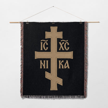 Black tapestry with a beige Orthodox Christian cross and Greek letters IC XC NIKA.