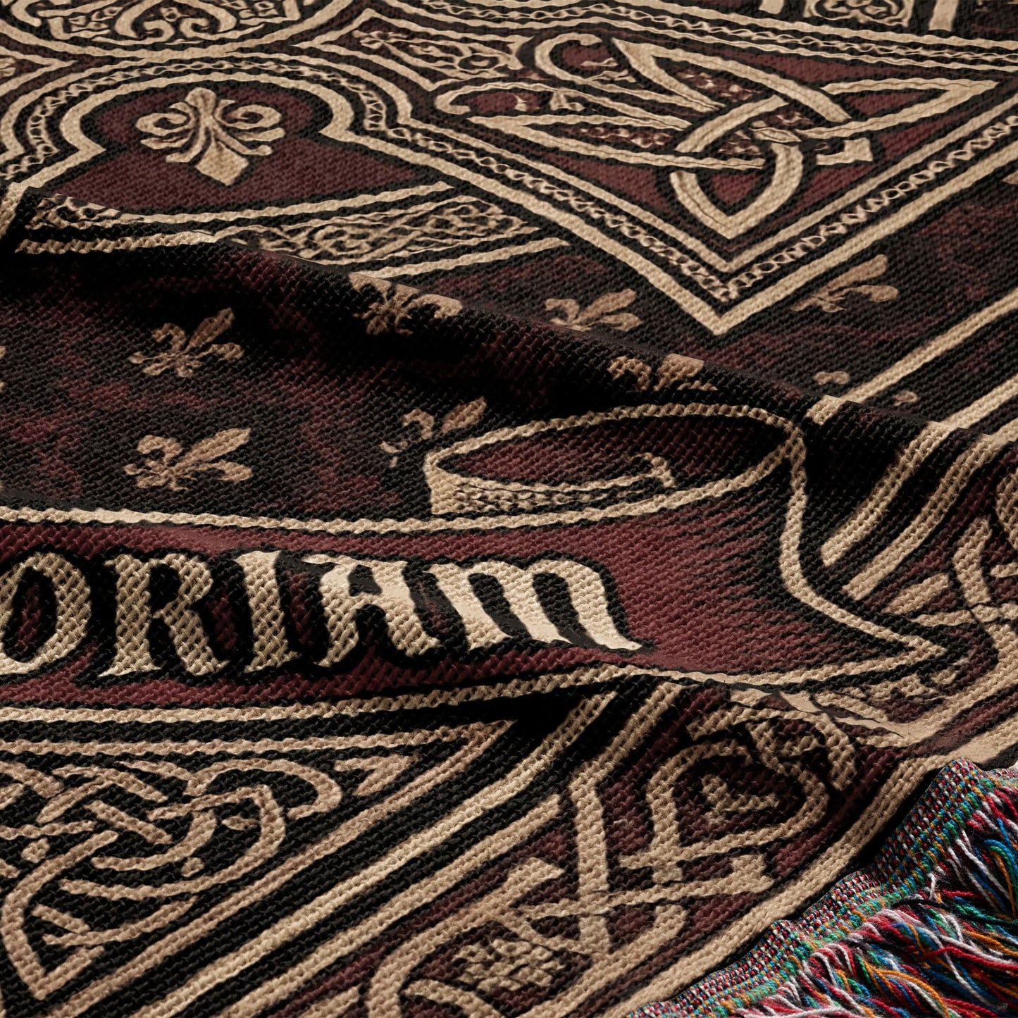 Close-up of a woven blanket with intricate Celtic knot and fleur-de-lis patterns, reading "DORIAM".
