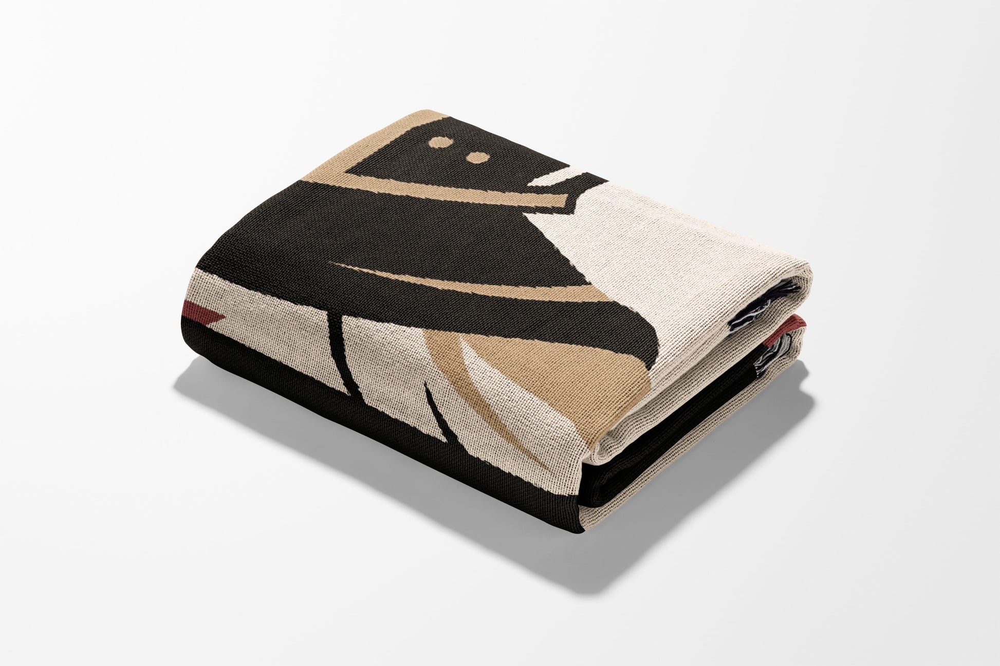 Folded blanket with geometric design featuring black, tan, and cream colors.