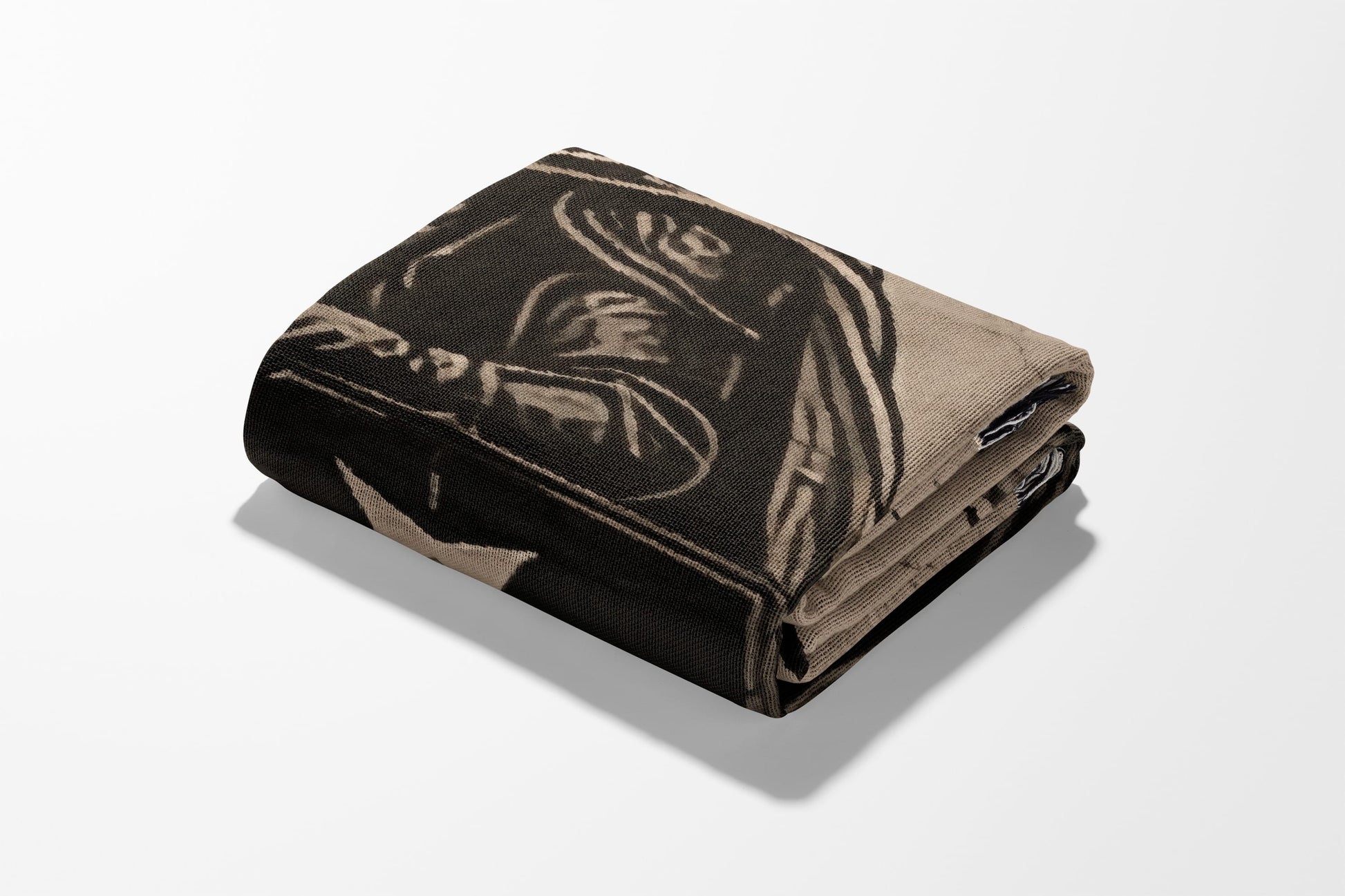 Folded blanket with a graphic pattern of a wolf and abstract lines.