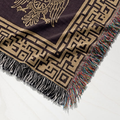 Brown blanket with eagle design and geometric border, fringed edges.
