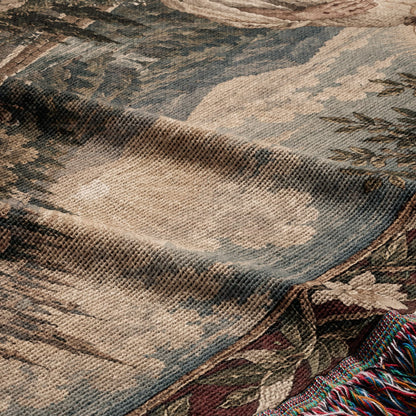 A woven blanket featuring a textured landscape pattern with muted tones of beige, green, and blue.
