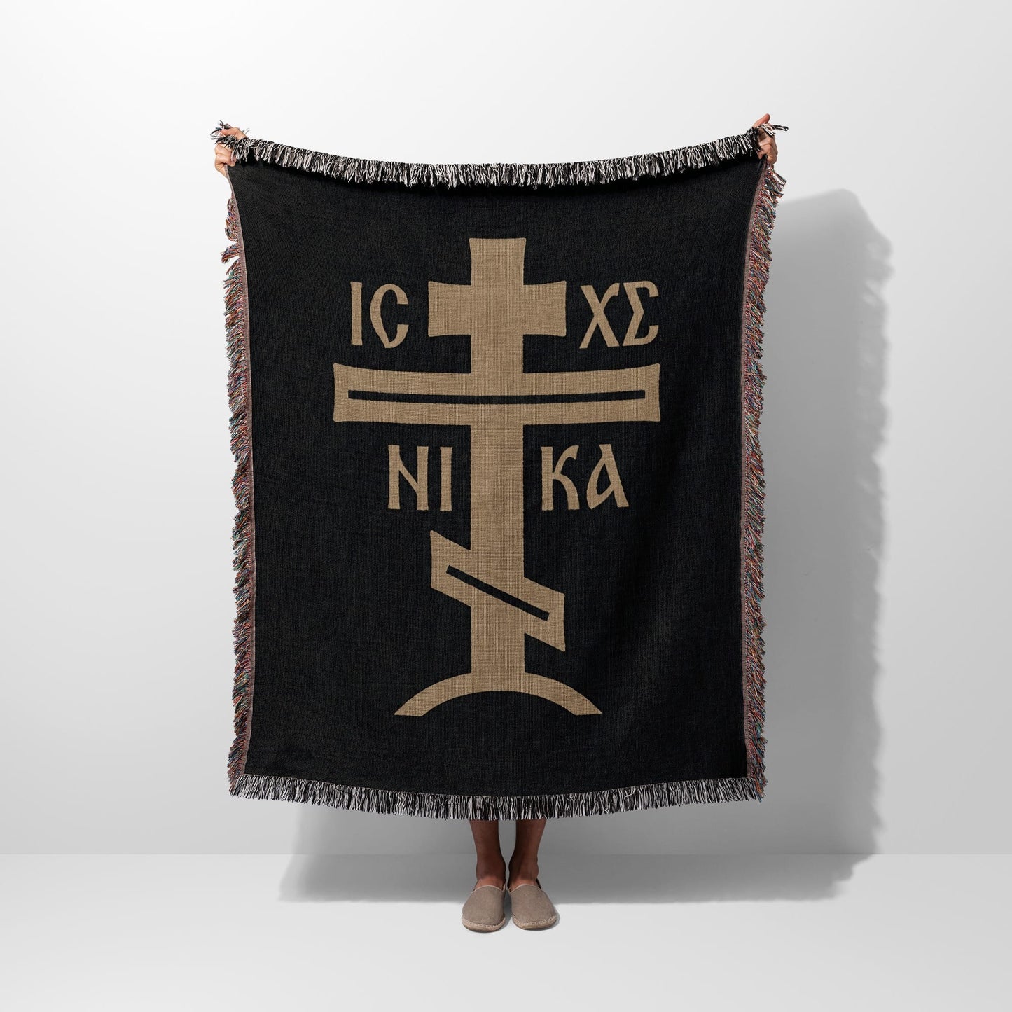 Black woven blanket with gold Orthodox Christian cross symbol.