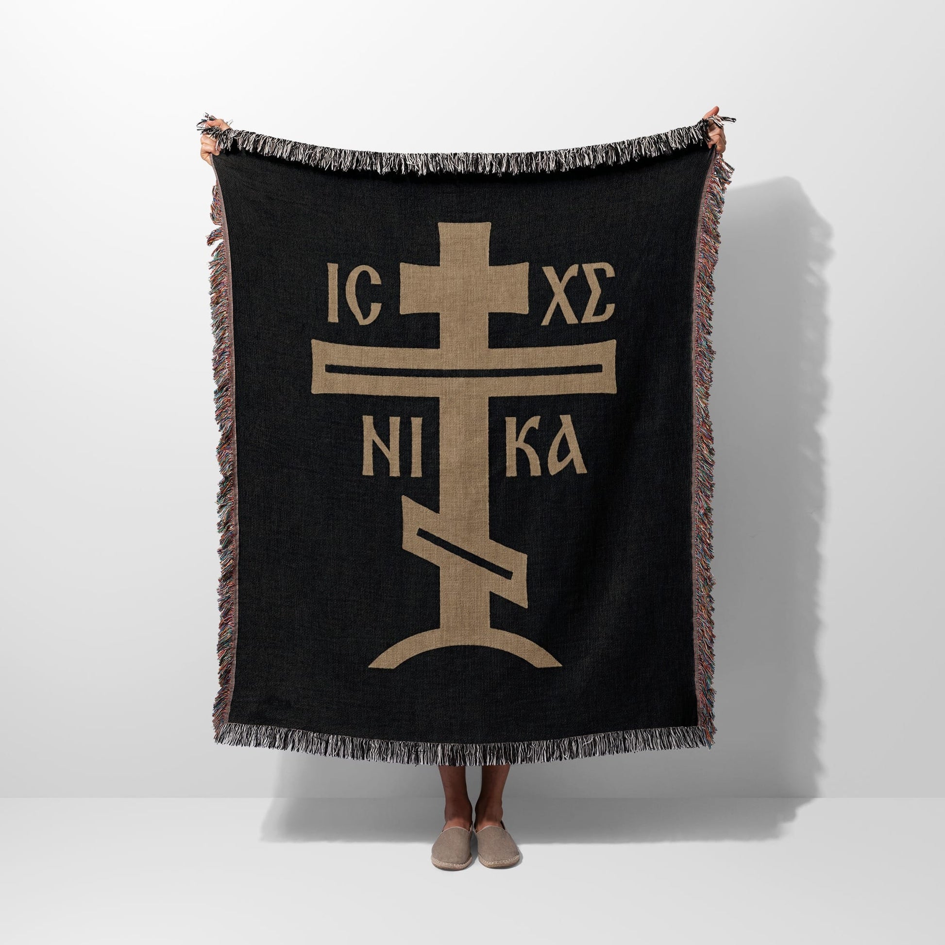 Black woven blanket with gold Orthodox Christian cross symbol.