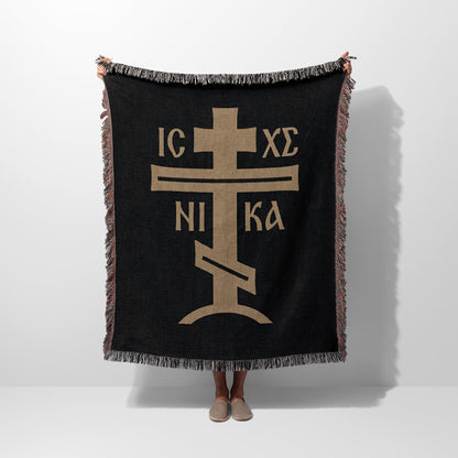 Black woven blanket with gold Orthodox Christian cross symbol.