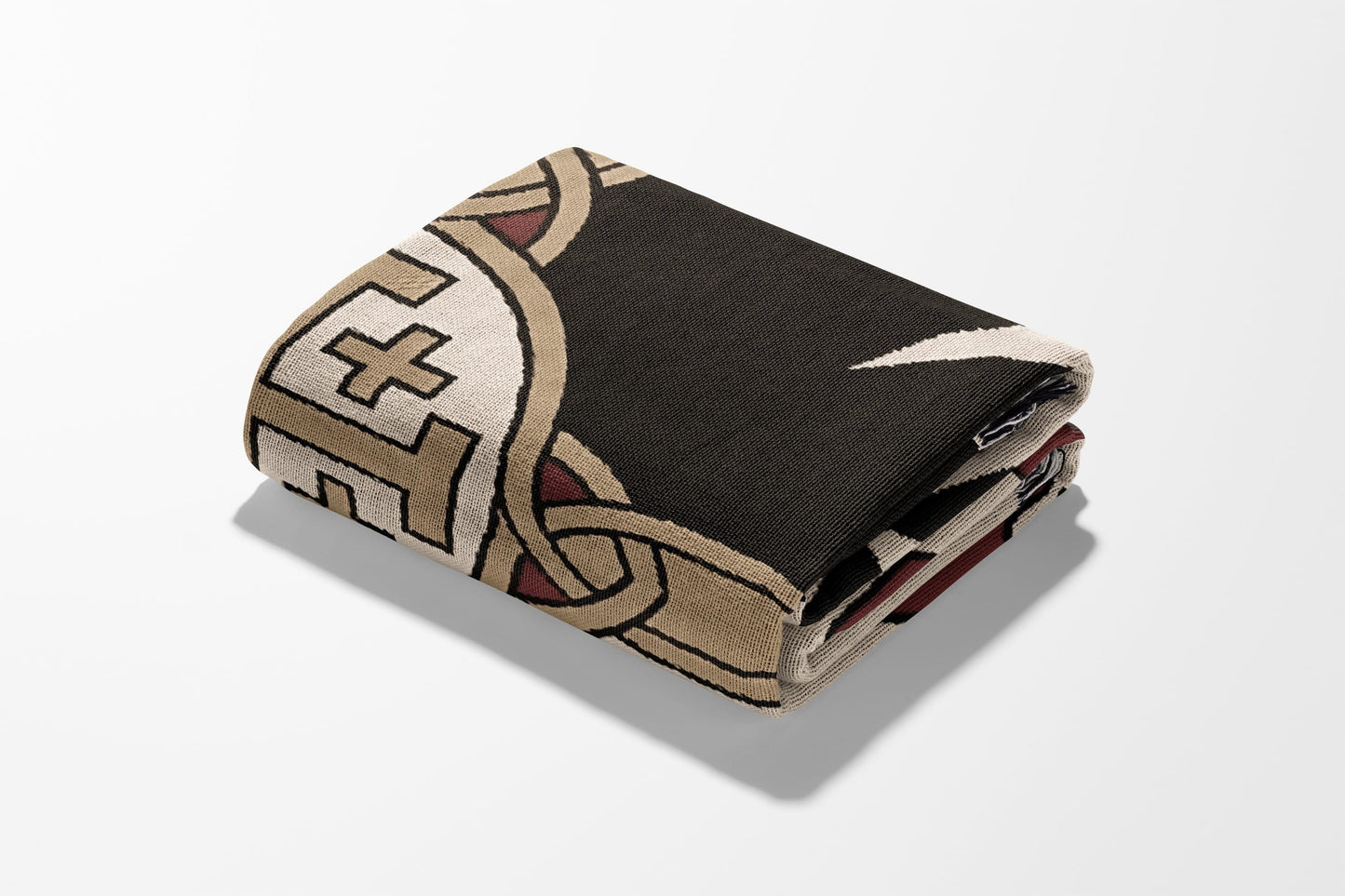 Folded blanket with intricate geometric and knotwork pattern.