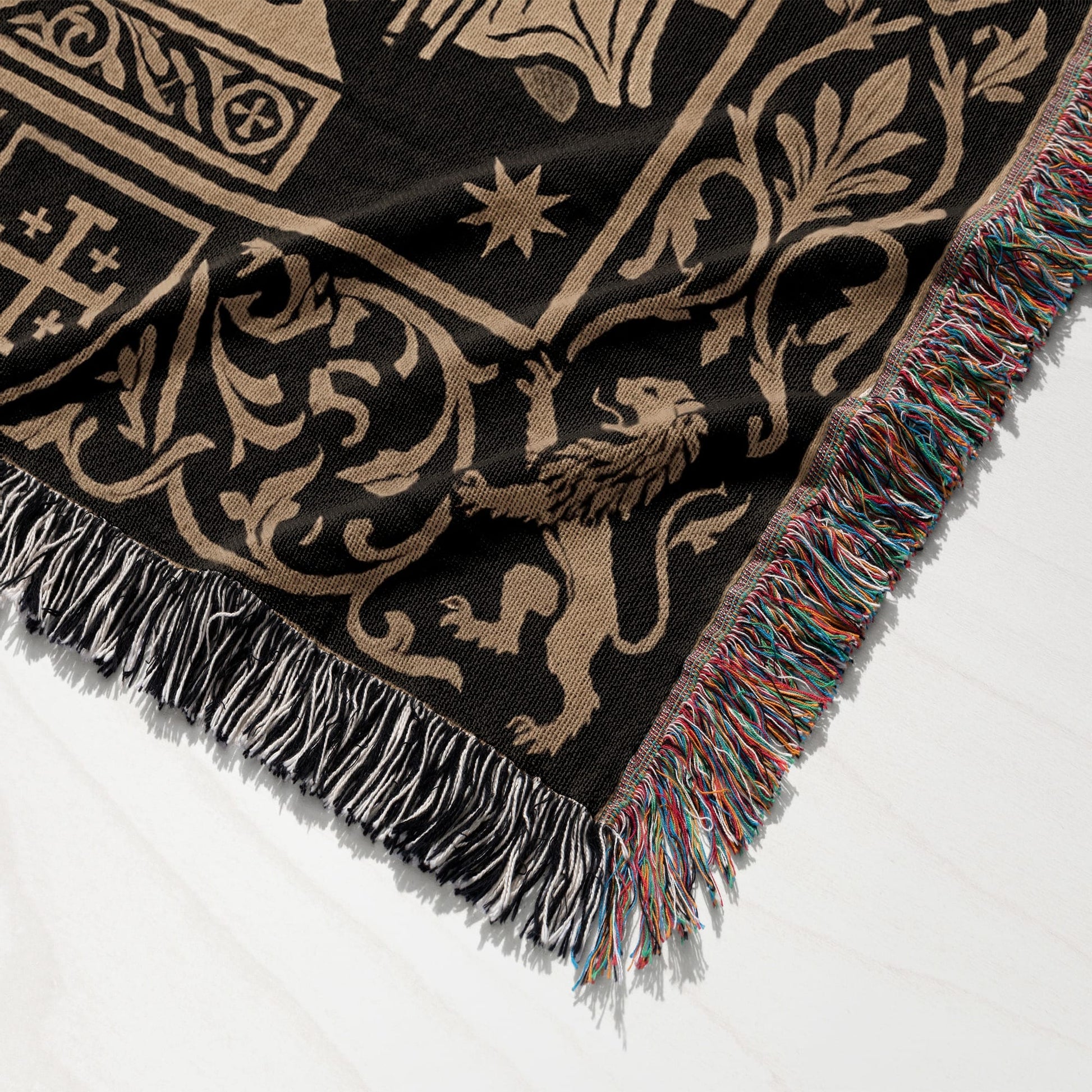 Black tapestry with a repeating tan medieval pattern of lions and foliage, fringed edges.