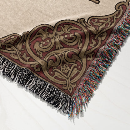 Woven throw blanket with ornate medieval-style pattern and multicolored fringe.