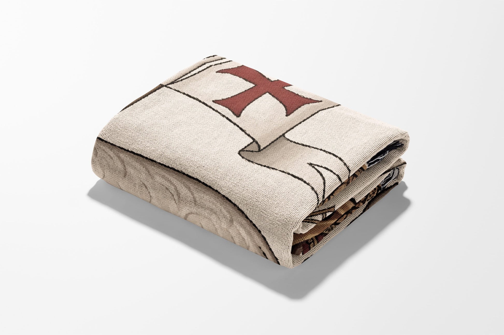 Folded tapestry blanket with red cross design on cream background.
