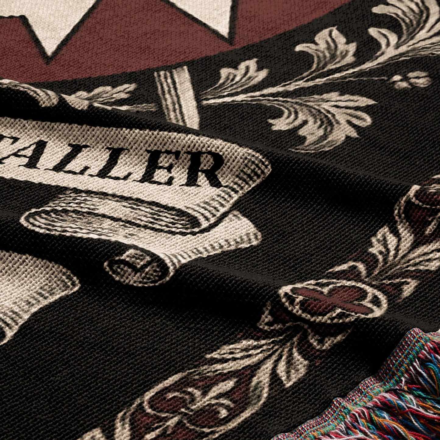 Black woven fabric with "TALLER" text and ornate scrolling patterns.