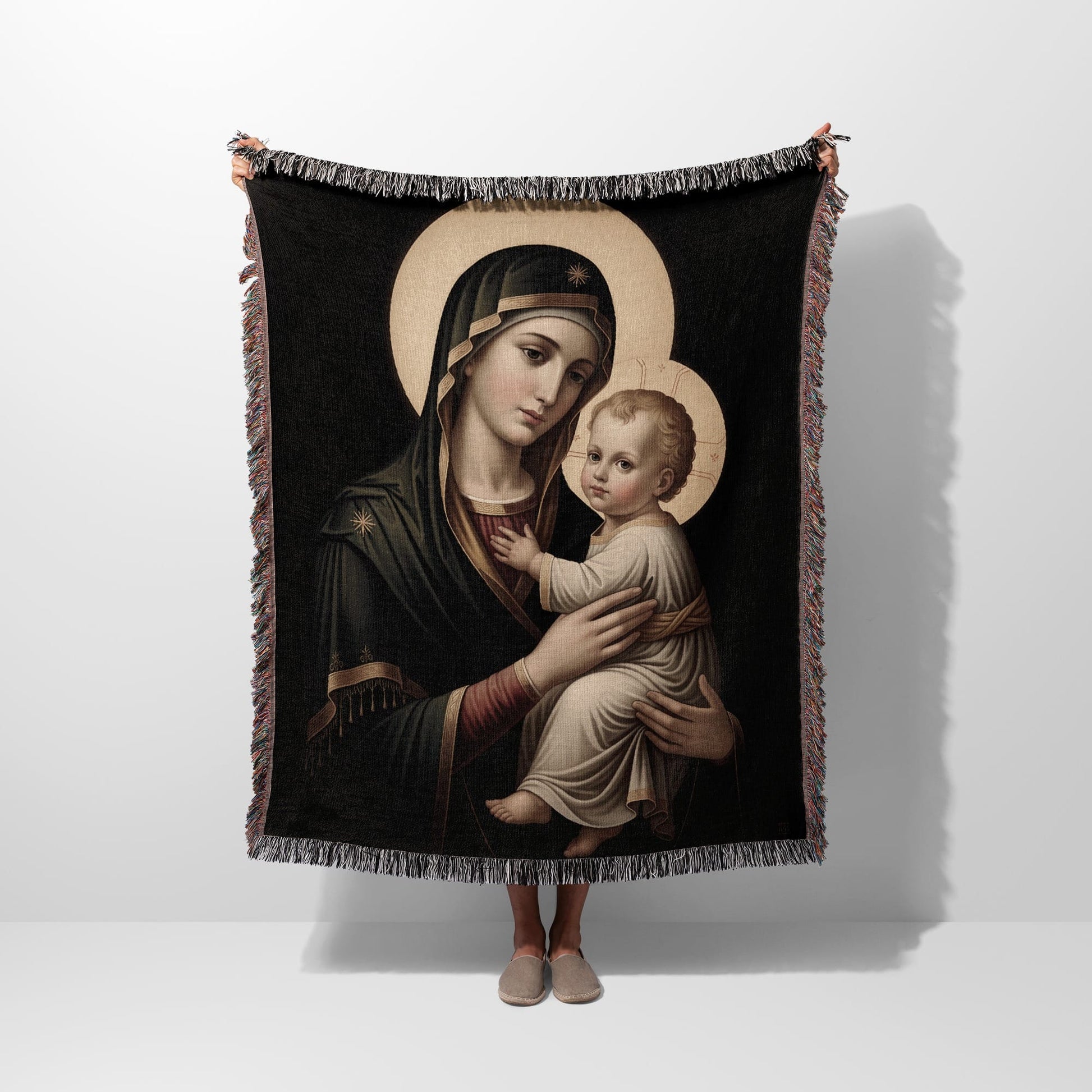 Tapestry of Madonna and Child with halo, held by unseen person.