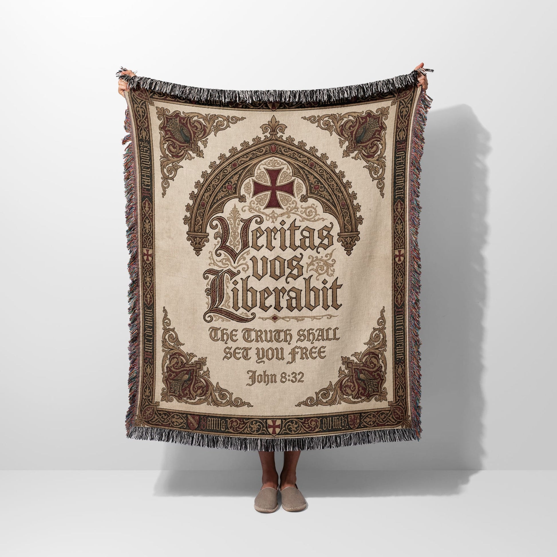 Woven blanket with a central cross and Latin inscription "Veritas vos liberabit".