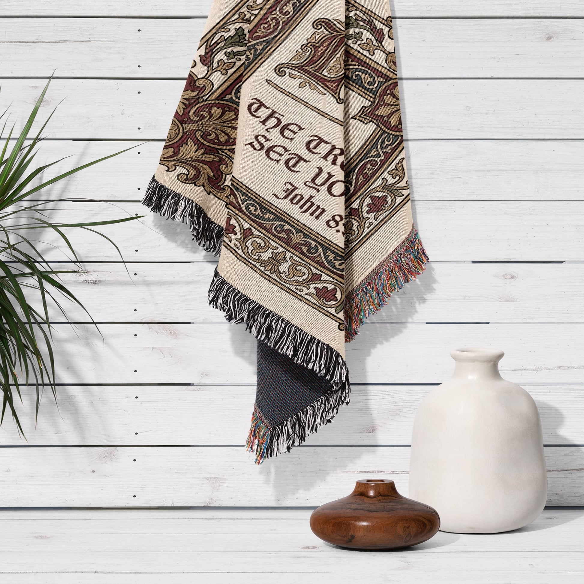 Woven tapestry with "The truth will set you free" text, fringed edges, hanging on wall.