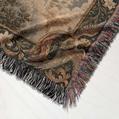 A folded woven blanket with a vintage tapestry design and multicolored fringe on a white surface.