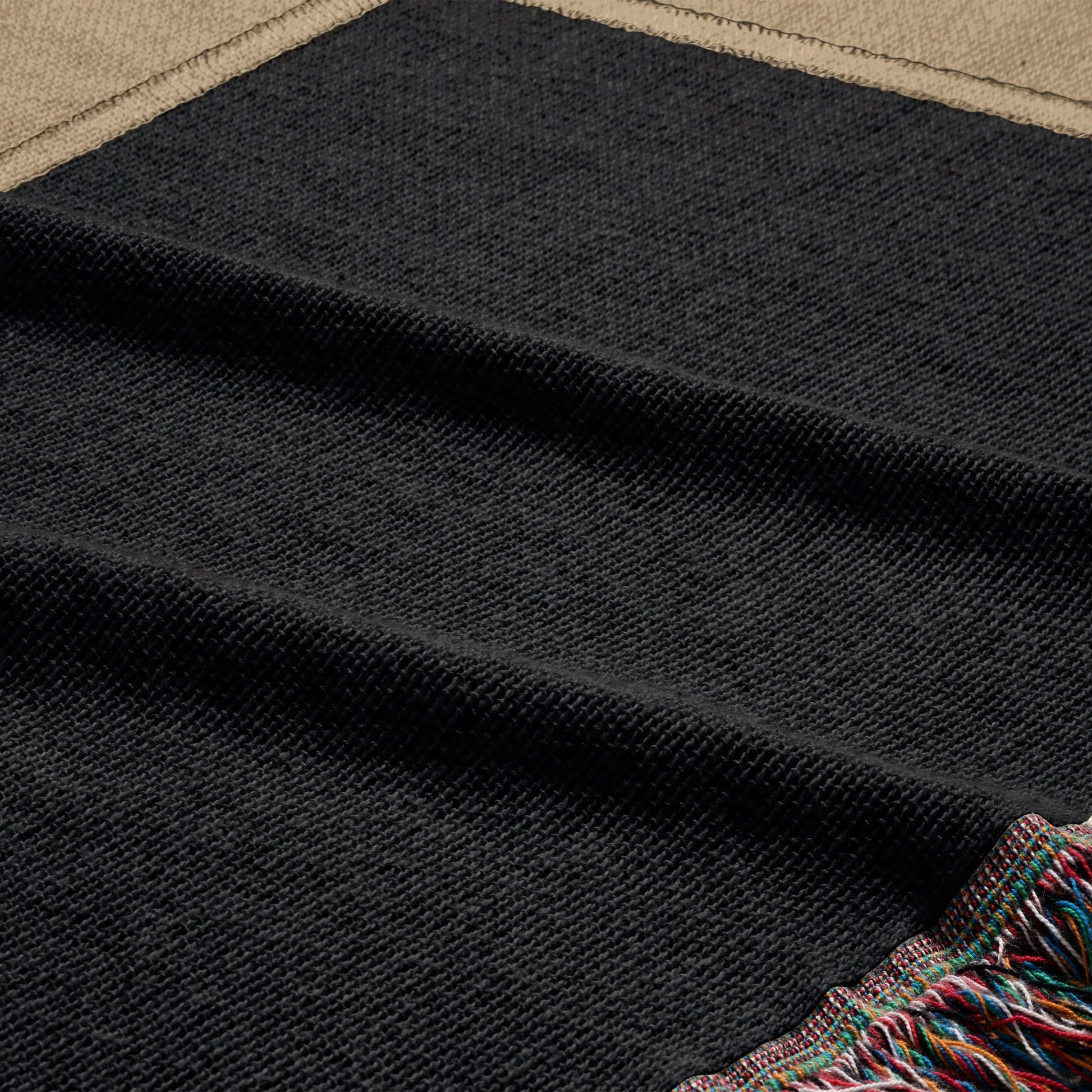 Textured black blanket with colorful fringe trim.