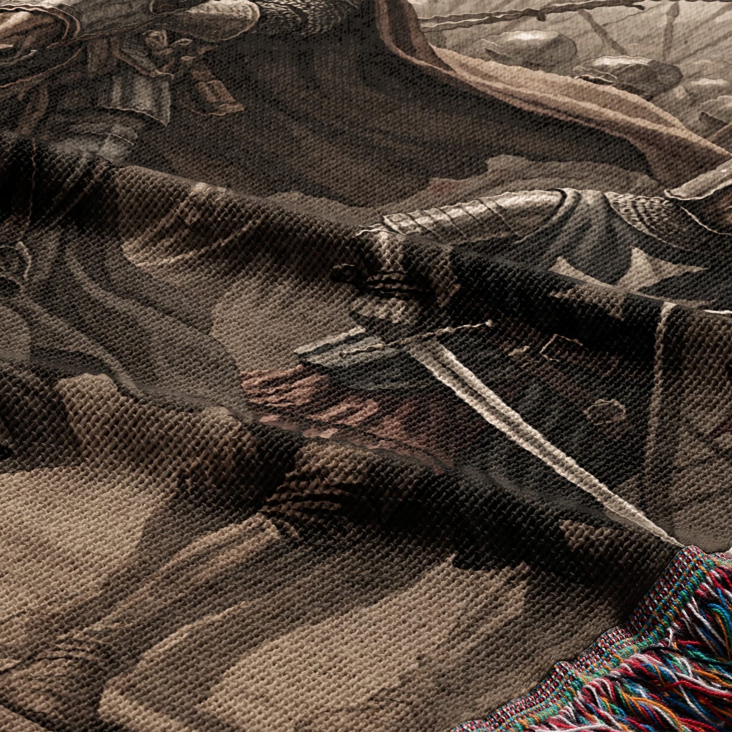 Tapestry detail showing knights in armor with swords and a fringed edge.