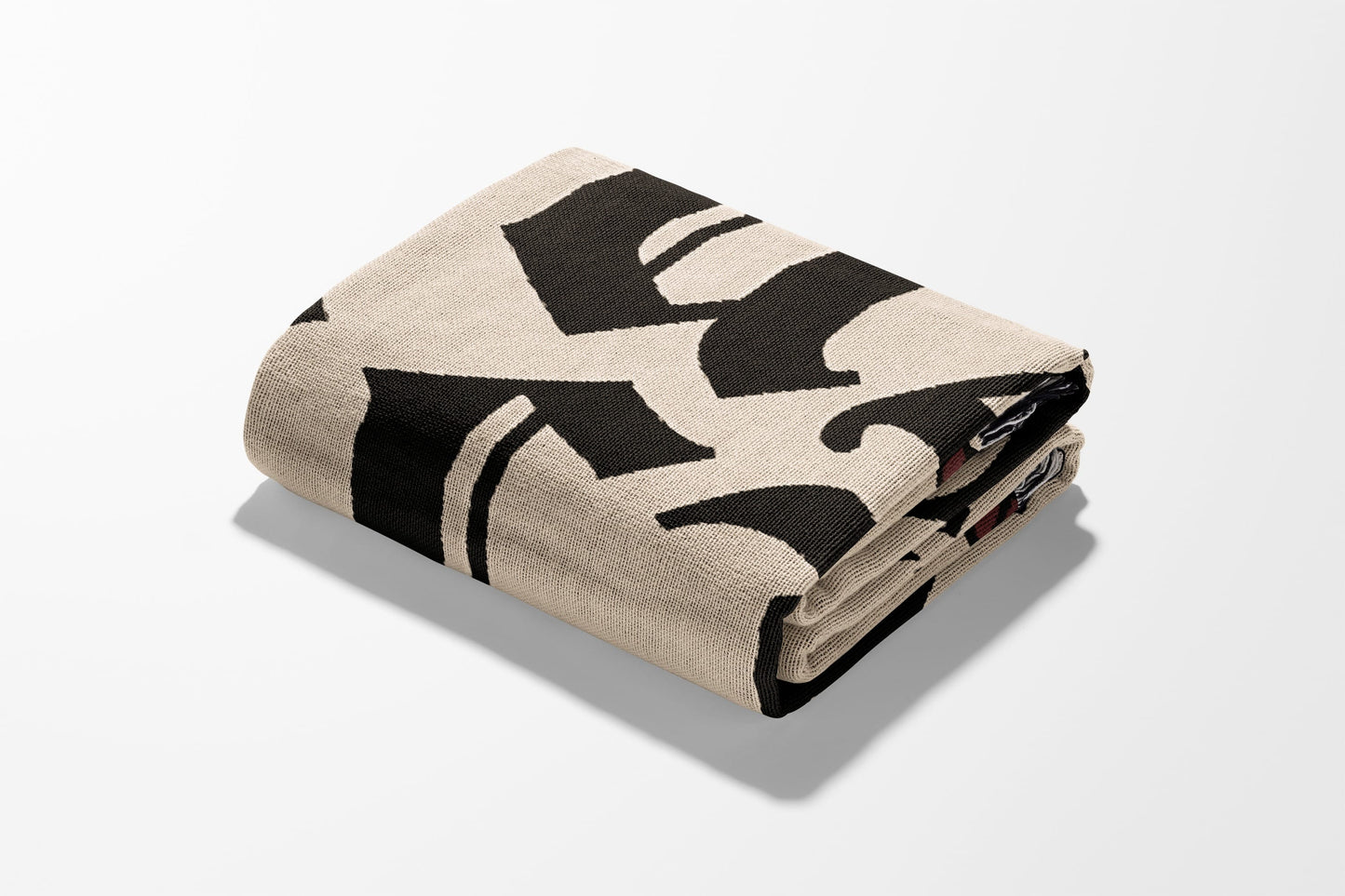 Folded beige blanket with bold black gothic lettering.