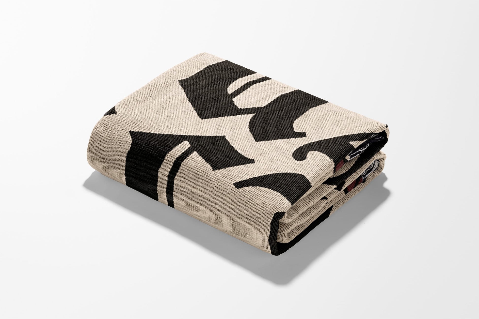 Folded beige blanket with bold black gothic lettering.
