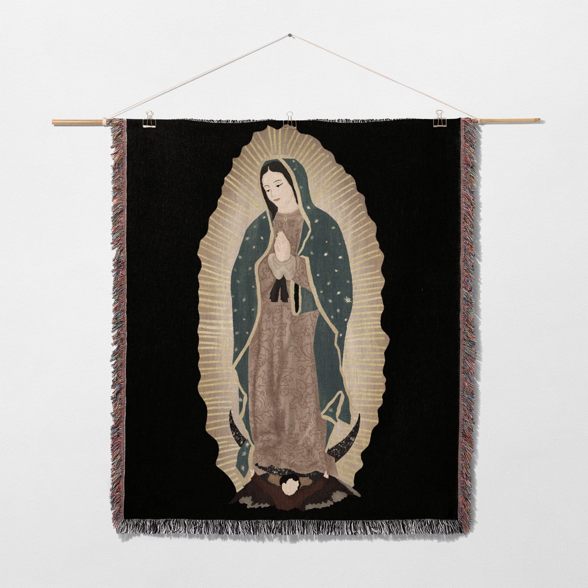Tapestry depicting the Virgin of Guadalupe with hands clasped, against a black background.