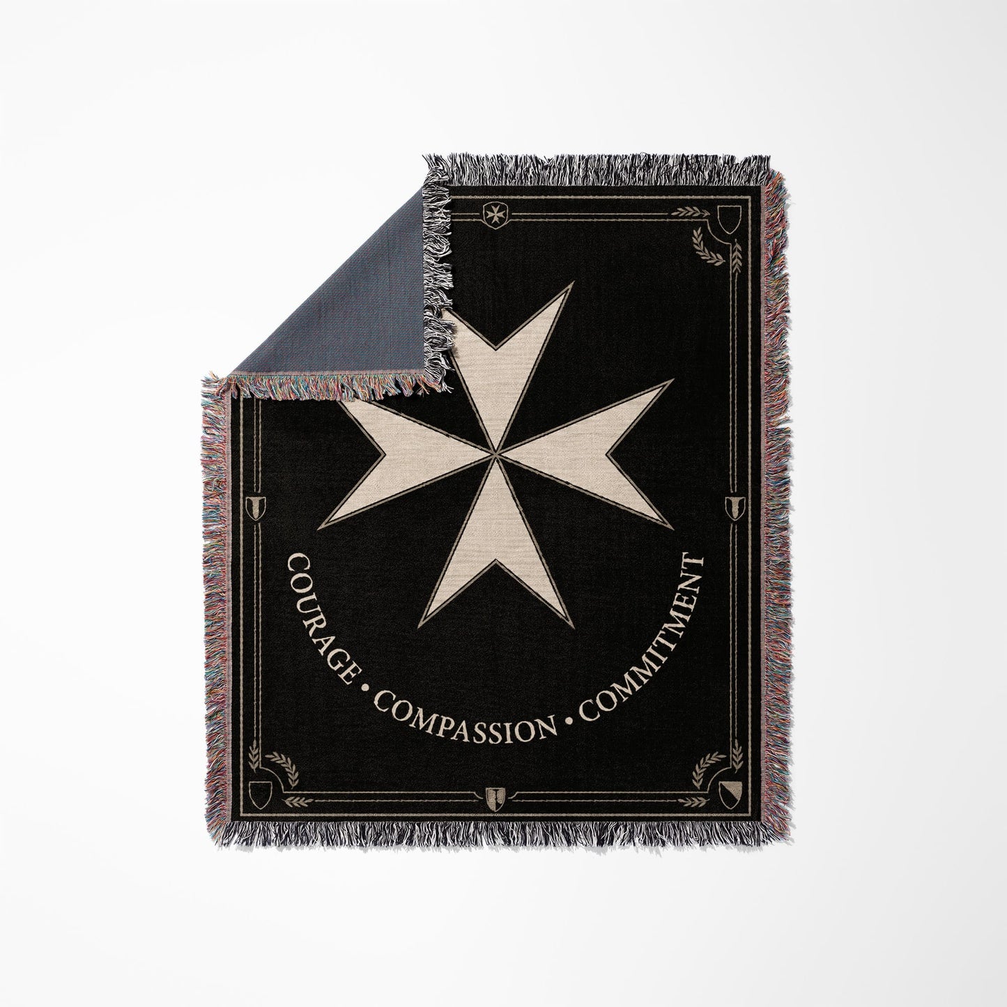 Black woven throw blanket with beige Maltese cross and text.