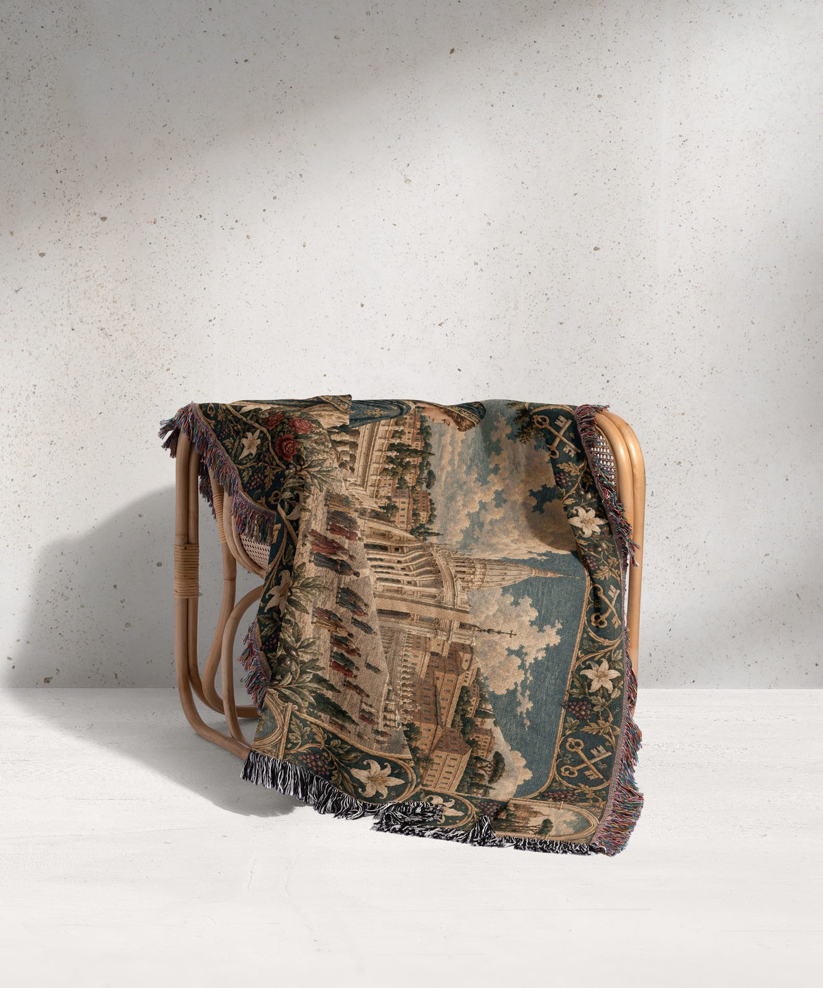 A patterned woven throw blanket draped over a light wood rattan armchair.