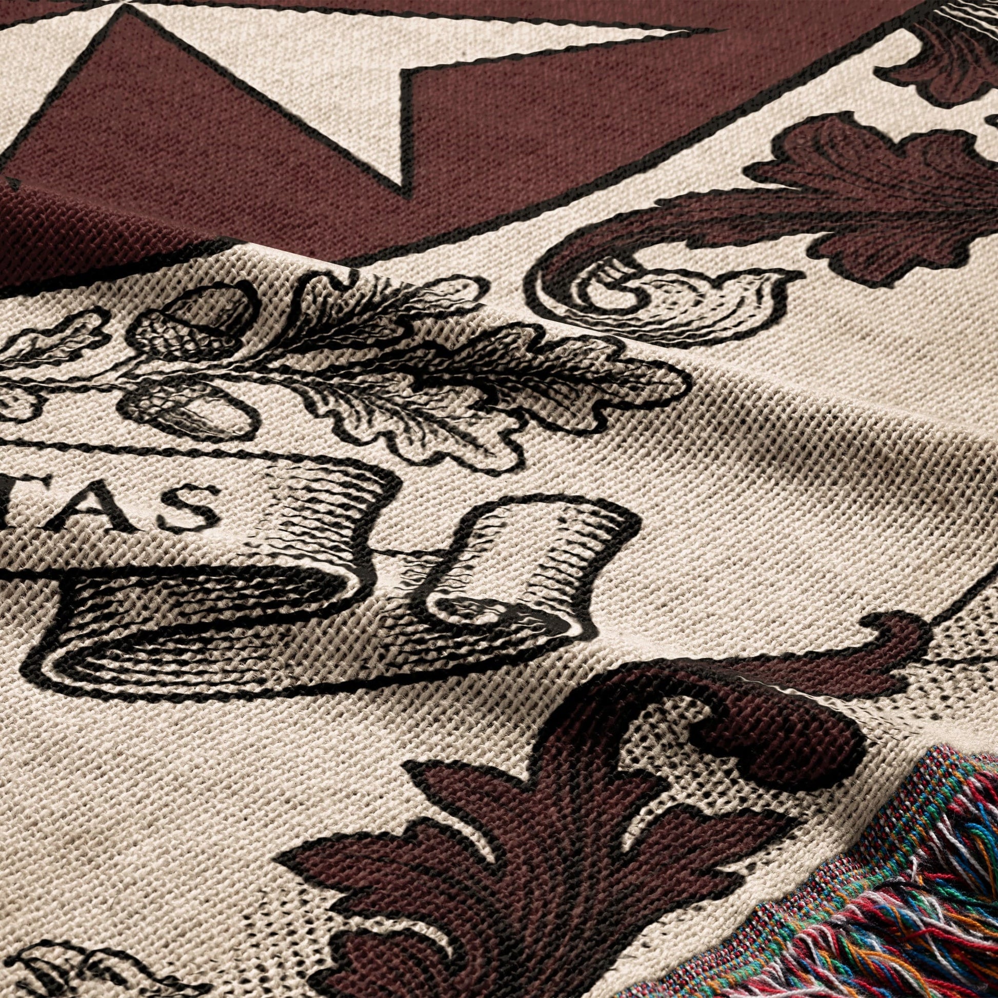 Cream woven blanket with brown oak leaves and text on a banner.