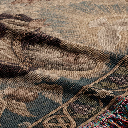 Folded woven tapestry featuring a vintage religious art motif with muted earth tones and fringed edges.