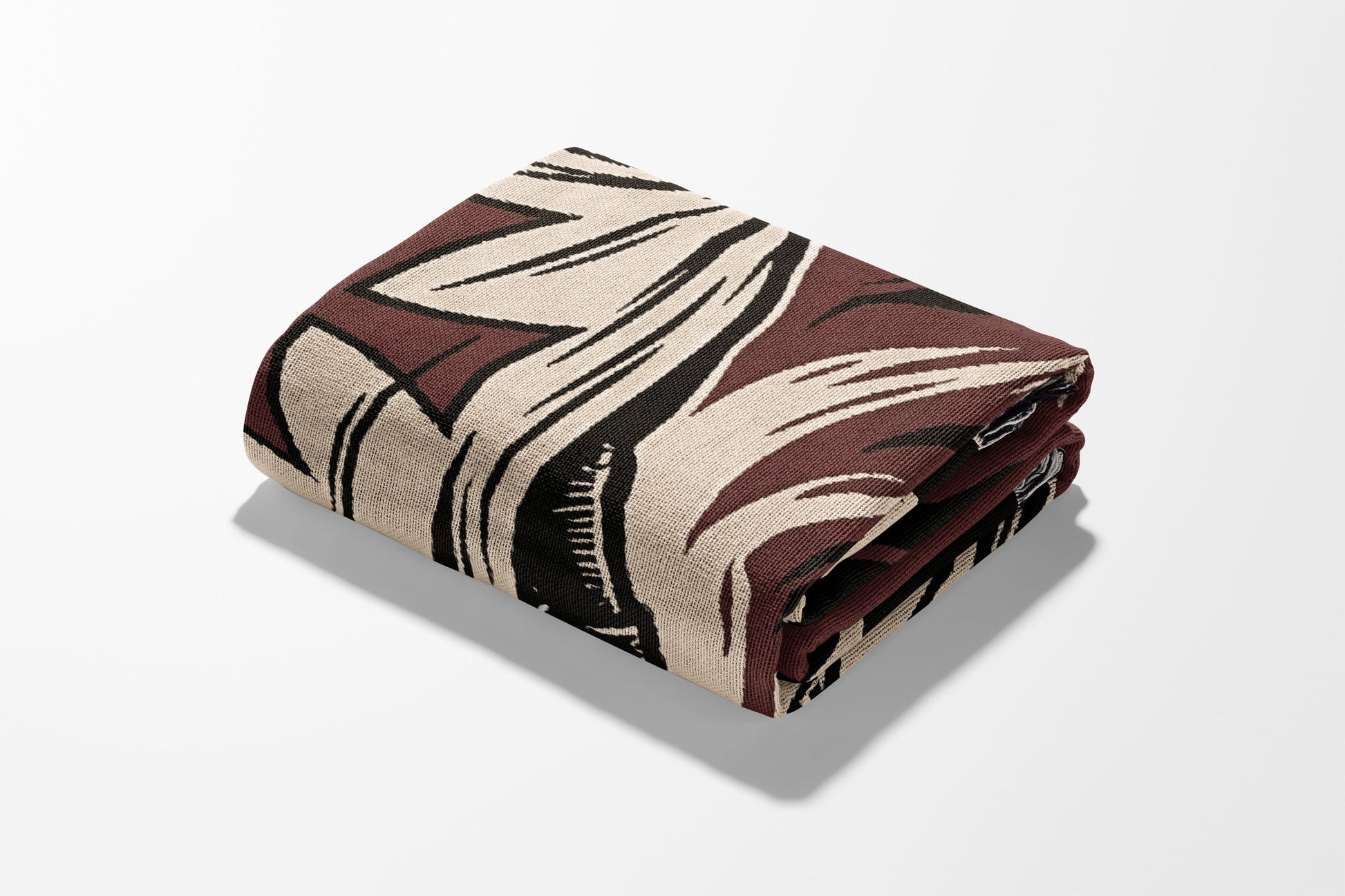 Folded blanket with a brown, black, and cream abstract pattern.