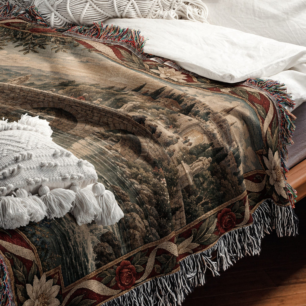 A woven tapestry-style blanket with a landscape scene drapes over a bed with white pillows.